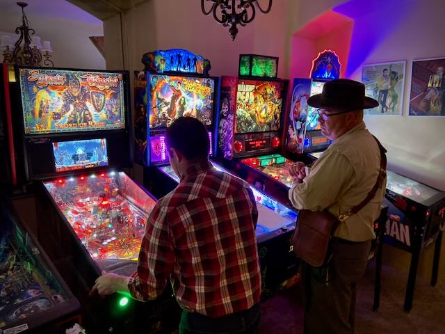 Costumed players working a row of machines on a Halloween league night
