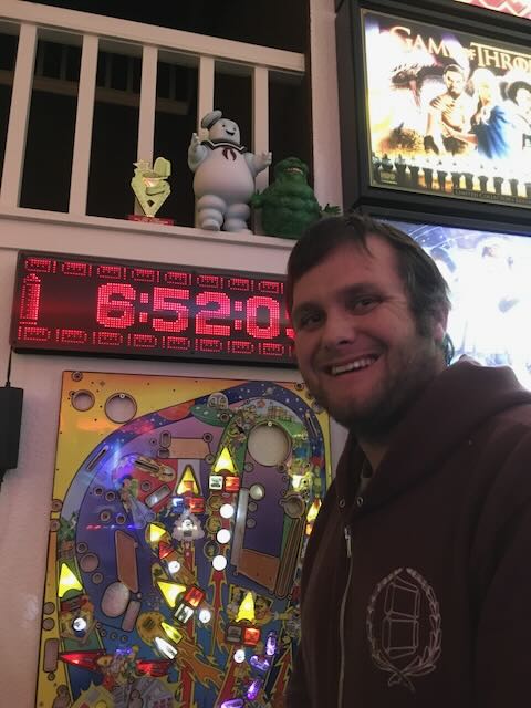 A player grinning beside a machine with the clock running